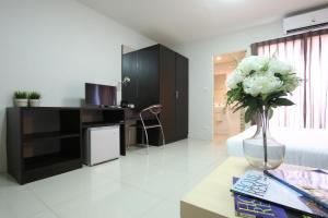 a living room with a vase of flowers on a table at The Bed by Boonjira in Chon Buri