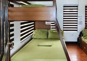 a bunk bed with a green mattress in a room at Tabique by the sea in Cebu City