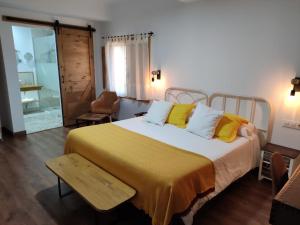 1 dormitorio con 1 cama grande con almohadas amarillas en Casa Rural el Rincón de Monfragüe, en Malpartida de Plasencia