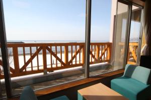 a room with a balcony with a view of the ocean at Spa SHIOSAI in Toyoura