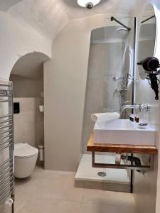 a bathroom with a toilet, sink, and bathtub at Hotel Kocour in Třebíč