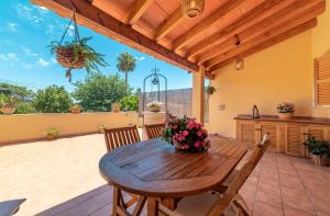 a wooden table and chairs on a patio at Villa Ca Na Campins in Campanet