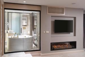 a bathroom with a tub and a tv and a fireplace at Walton Gardens Pera in Istanbul