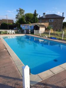 ein großer Pool mit blauem Wasser im Hof in der Unterkunft les gites de la bouldoire Renaissance in Rignac