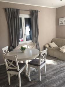 Casa vacanze Villetta San Pietro 9 في ديانو مارينا: طاولة بيضاء وكراسي في غرفة المعيشة