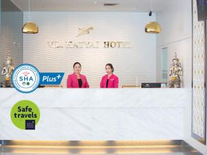 two women standing behind a counter in a store at V.L. Hatyai Hotel in Hat Yai