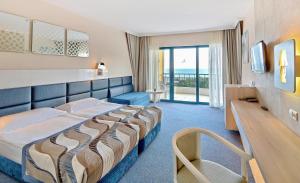 Cette chambre d'hôtel comprend un lit et offre une vue sur l'océan. dans l'établissement GRIFID Arabella Hotel - Ultra All inclusive & Aquapark, aux Sables d'or