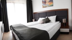 una camera con un grande letto con testiera nera di Apart & Spa Zoned a Kopaonik