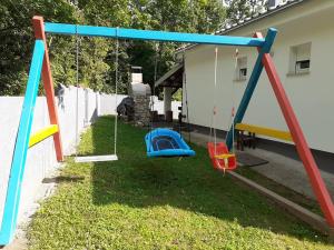 a playground with swings in a yard at Villa Manta Crikvenica in Crikvenica