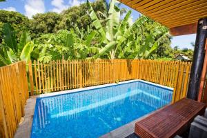 Nevaeh Holiday Home plus Pool في أفاروا: مسبح بسياج خشبي ومقاعد خشبية