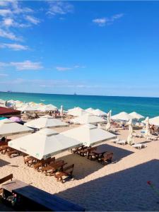 a beach with white umbrellas and chairs and the ocean at Aqua Villa by the Sea in Eforie Sud +52 photos