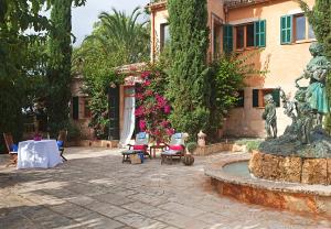 a courtyard with a statue and a fountain in front of a building at Es Revellar Art Resort - Adults Only in Campos