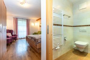 łazienka z łóżkiem, prysznicem i toaletą w obiekcie Brandstatthof Leogang w mieście Leogang