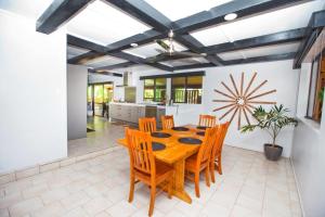 阿瓦魯阿的住宿－Nevaeh Holiday Home plus Pool，一间带木桌和椅子的用餐室