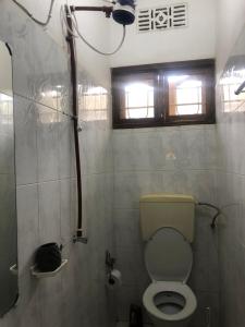 a small bathroom with a toilet and a window at Safari Adventures-House in Arusha +60 photos