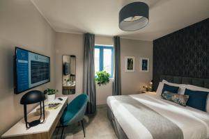 a hotel room with a bed and a desk and a tv at Amery House in Sliema