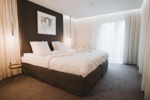 a large bed in a room with a window at Vaeshartelt Maastricht - Free Parking in Maastricht