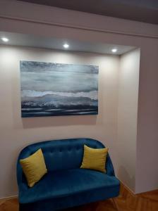マコーにあるZenit Apartmanの壁画のある部屋の青いソファ