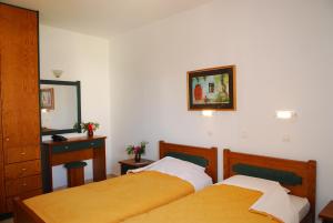 a bedroom with two beds and a mirror at Apollo City Hotel - Maliatim in Malia