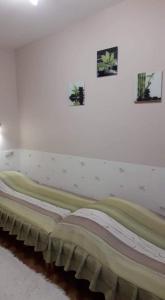 マコーにあるZenit Apartmanの壁に2枚の写真が飾られた部屋のベッド1台分です。