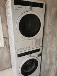 una lavadora y una secadora sentadas una al lado de la otra en Hurthi Apartment - Blue House, en Vardø