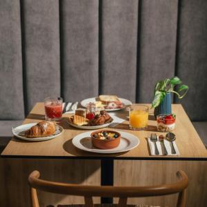 a wooden table with plates of food and drinks at Amery House in Sliema