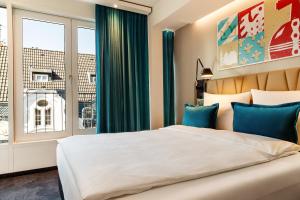 Postel nebo postele na pokoji v ubytování Motel One Aachen