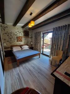 a bedroom with a bed and a large window at Pensiunea Casa Dacilor in Podeni