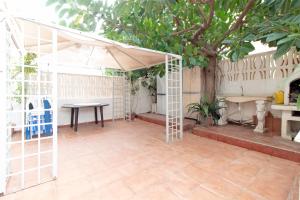 eine Terrasse mit einem Zelt, einem Tisch und einem Baum in der Unterkunft Global Properties, Apartamento 2 dormitorios en Canet d'en Berenguer in Canet d'en Berenguer