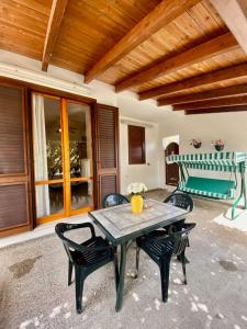 un patio con mesa, sillas y banco en ADV Holiday House - Casa Vacanze, en San Cataldo