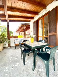 una mesa verde y sillas en un patio en ADV Holiday House - Casa Vacanze, en San Cataldo