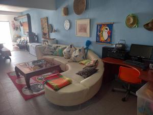 een woonkamer met een bank en een bureau bij Casa da Gó in Ericeira