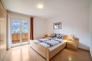 een slaapkamer met een bed en een groot raam bij Ferienwohnung Ortler in Saltusio