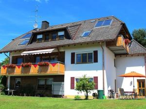a large house with a balcony and an umbrella at Haus Leufke in Lenzkirch