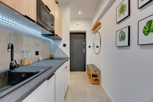 a kitchen with a sink and a counter top at Ideal Apartments Arkady in Gdańsk