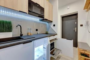 a kitchen with a sink and a microwave at Ideal Apartments Arkady in Gdańsk