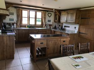 a large kitchen with wooden cabinets and a table at Cosy Cottage in the Countryside in Stafford