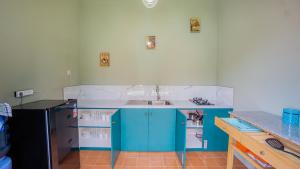 uma cozinha com armários azuis e um lavatório em Villa Joglo Kawung em Yogyakarta