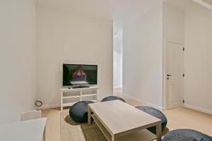 un salon avec une table, des chaises et une télévision dans l'établissement Maison Perron, à La Panne