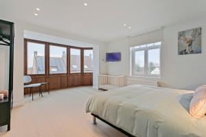 une chambre avec un lit, un bureau et une télévision dans l'établissement Maison Perron, à La Panne