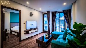 a living room with a blue couch and a television at VNAHOMES APARTHOTEL in Hanoi