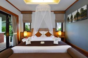 a bedroom with a large bed with elephant pillows at Phangan Bayshore Resort Koh Phangan in Haad Rin