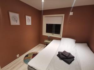 Un dormitorio con una cama con un sombrero encima. en Hurthi Apartment - Blue House, en Vardø