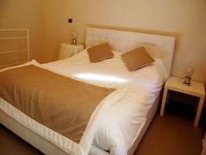 uma grande cama branca com duas almofadas em Residenza il Nespolo - Estella Hotel Collection em Turim