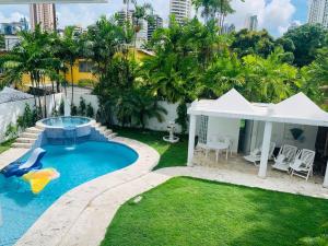 a backyard with a pool and a slide in the grass at Casa Duplex Privada con Piscina in Panama City