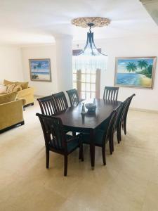a dining room table with chairs and a chandelier at Casa Duplex Privada con Piscina with Ride from Airport in Panama City