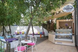 a cafe with tables and chairs under a tree at GRIFID Arabella Hotel - Ultra All inclusive & Aquapark in Golden Sands