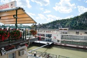 a boat on a river with people on a balcony at Liana-Luxury And Central Flat in Budapest