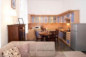 ein Wohnzimmer mit einem Sofa und einer Küche in der Unterkunft Liana-Luxury And Central Flat in Budapest