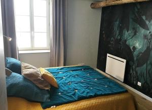 1 cama con edredón azul en un dormitorio en L'HIVERNET, grand Triplex neuf au cœur d'Embrun accès facile, en Embrun